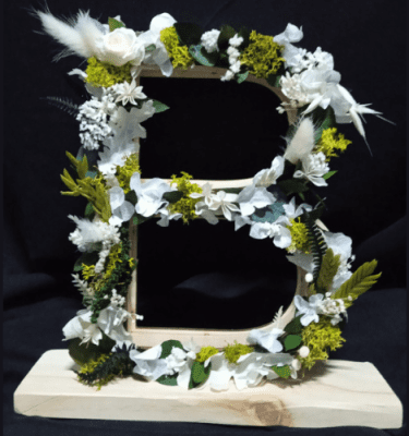 Letra de madera en flores preservadas